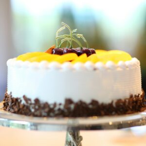 Elegant cake with fruits and chocolate shavings, perfect for celebrations.